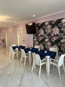 a dining room with tables and chairs and a tv on a wall at Mare Azzurro in Marina di Camerota