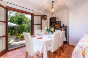 a dining room with a white table and chairs at Na Forana in Cala Ratjada