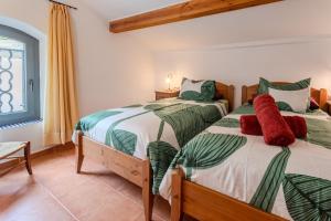 a bedroom with two beds with green and white sheets at Mas Vinyoles 2 in Montnegre +20 photos