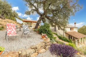a yard with two chairs and a tree at Mas Vinyoles 2 in Montnegre