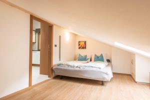 a bedroom with a bed with blue pillows at Apt Hetti - Haus Kostner in Santa Cristina Gherdëina