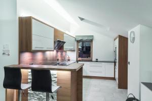 a kitchen with a counter with two black chairs at Apt Hetti - Haus Kostner in Santa Cristina Gherdëina