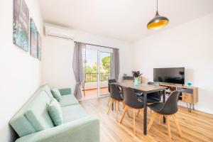 a living room with a couch and a table and chairs at Gran Sol Family 5 in Felanitx