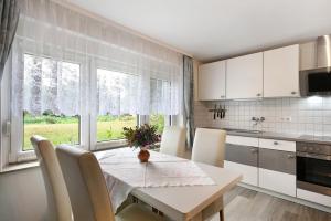 a kitchen with a table and chairs and a kitchen with white cabinets at Ferienwohnung Shaun in Blankenburg