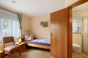 a bedroom with a bed and a toilet and a window at Ferienwohnung Shaun in Blankenburg