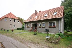a gray house with a red roof and a white house at Ferienwohnung Shaun in Blankenburg