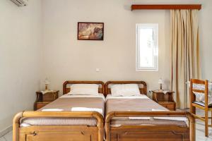 two twin beds in a room with a window at Daratos studio 1 in Kefallonia