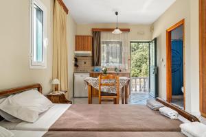 a bedroom with a bed and a kitchen with a table at Daratos studio 1 in Kefallonia