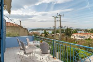 a patio with a table and chairs on a balcony at Joan Serenity Apartment in Porto Heli