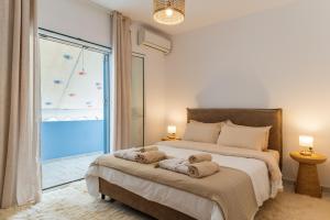 a bedroom with a large bed with towels on it at Joan Serenity Apartment in Porto Heli