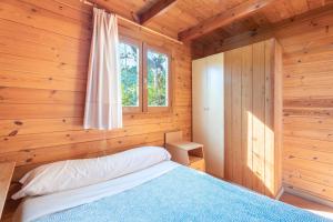 a bedroom with a bed in a wooden cabin at Falaguera Cabaña 2 in Bárig +21 photos