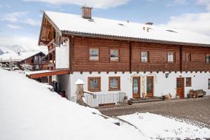 a wooden house with snow on the ground at Ferienwohnung König im Erdgeschoss in Berchtesgaden