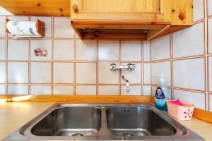 a stainless steel sink in a kitchen with wooden cabinets at Casa Zarina Well-kept Two-room in Cavalese +17 photos