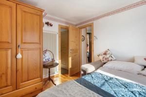 a bedroom with a bed and a couch at Casa Zarina Well-kept Two-room in Cavalese