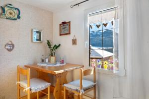 a dining room table with two chairs and a window at Casa Zarina Well-kept Two-room in Cavalese