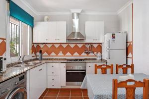 a kitchen with white cabinets and a stove top oven at Casa Antonia 2 in Conil de la Frontera