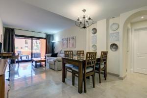 a dining room and living room with a table and chairs at Superb 2-bed apartment in Duquesa in Manilva