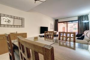 a dining room and living room with a table and chairs at Superb 2-bed apartment in Duquesa in Manilva