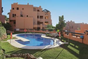 a swimming pool in the yard of a building at Superb 2-bed apartment in Duquesa in Manilva