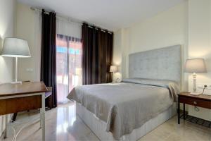 a bedroom with a bed and a desk and a window at Superb 2-bed apartment in Duquesa in Manilva +26 photos
