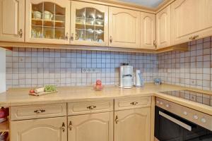 a kitchen with wooden cabinets and a counter top at Ferienwohnung König im Erdgeschoss in Berchtesgaden