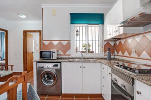 a kitchen with a washing machine and a microwave at Casa Antonia 2 in Conil de la Frontera +17 photos