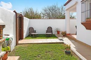 a patio with chairs and grass in a backyard at Casa Antonia 2 in Conil de la Frontera