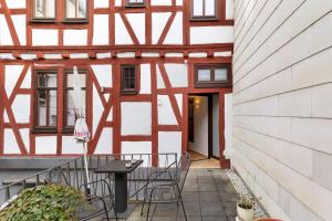 a balcony with chairs and a table in front of a building at Traumschlüsselchen in Braubach