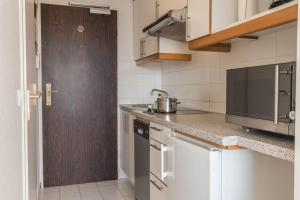 a kitchen with white cabinets and a wooden door at Fewo Blick über Sylt in Westerland +10 photos