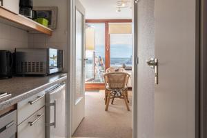 a kitchen with a microwave and a table with a chair at Fewo Blick über Sylt in Westerland