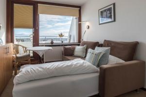 a living room with a couch and a large window at Fewo Blick über Sylt in Westerland