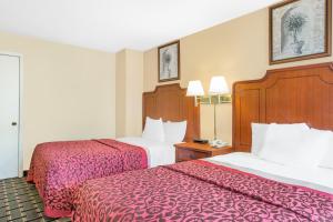 a hotel room with two beds with red sheets at Meridian Inn in Meridian