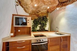a kitchen with a sink and a tv in a cave at Villa La Cueva in Teguise
