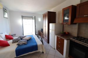 a bedroom with a large bed and a kitchen at Casa vacanze Frida in Salento in Otranto