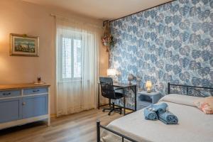 a bedroom with two beds and a desk with a chair at Da Susy - Aria condizionata in Pescia