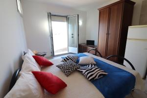 a bed with pillows on it in a room at Casa vacanze Frida in Salento in Otranto