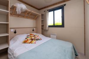 a bedroom with a bed and a window at Chalet 25m2 - La Vieille in Plouhinec