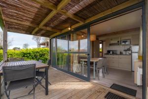 an open patio with a table and chairs on a deck at Chalet 25m2 - La Vieille in Plouhinec