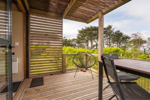 a wooden deck with a table and a chair on it at Chalet 25m2 - La Vieille in Plouhinec +12 photos