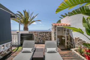 a patio with chaise lounges and the ocean at Paraíso Radazul in Radazul
