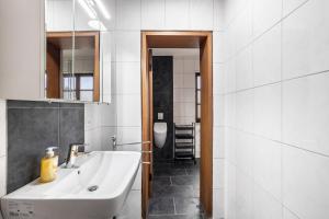 a bathroom with a white sink and a toilet at Ferienwohnung Brunnenblick in Pottenstein +21 photos