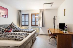a bedroom with a bed and a desk with a computer at Ferienwohnung Brunnenblick in Pottenstein
