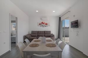 a dining room with a table and chairs and a couch at El Descanso in Conil de la Frontera