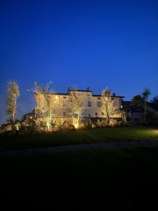 a large white house with lights in front of it at Residence Palmento in Franciacorta in Corte Franca