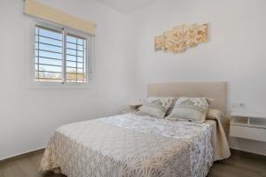 a white bedroom with a bed and a window at El Descanso in Conil de la Frontera +18 photos