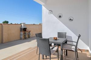 a patio with a table and chairs on a balcony at El Descanso in Conil de la Frontera