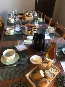 a long wooden table with food and drinks on it at Suite familiale - Gîte du Moulin in La Noue +9 photos