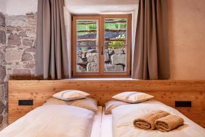 two beds in a room with a window at Egger an der Lahn - Apt Nonna in San Genesio Atesino