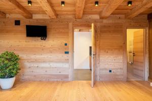 a room with a door and a tv on a wall at Egger an der Lahn - Apt Nonna in San Genesio Atesino