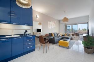 a kitchen with blue cabinets and a living room at Casa Noa in Costa Del Silencio